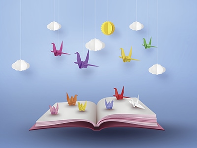 origami made colorful paper bird flying over open book