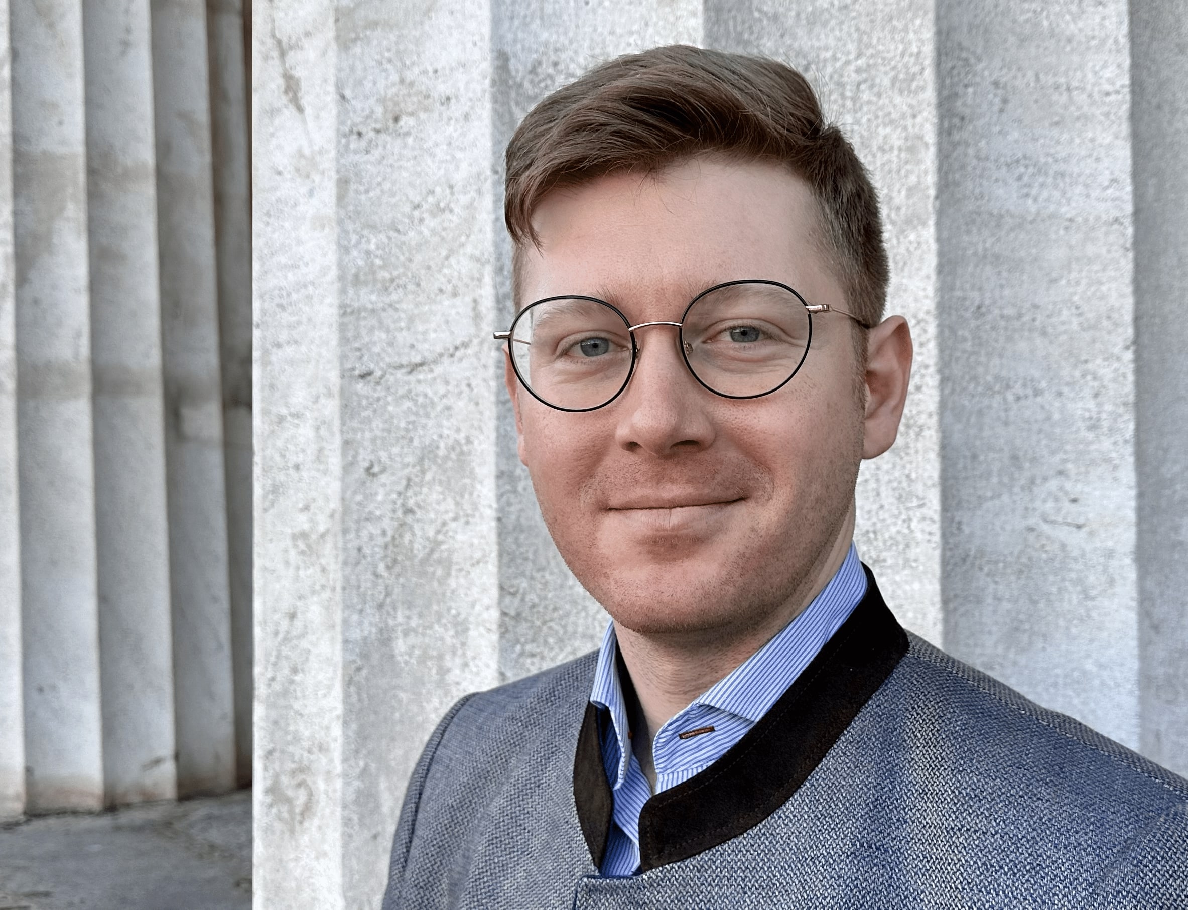 Fortepianist Daniel Adam Maltz standing in front of columns in Vienna
