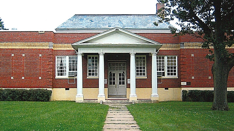 Photo of school with red walls and columns.